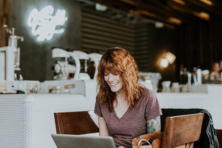 female-smiling-cafe-laptop